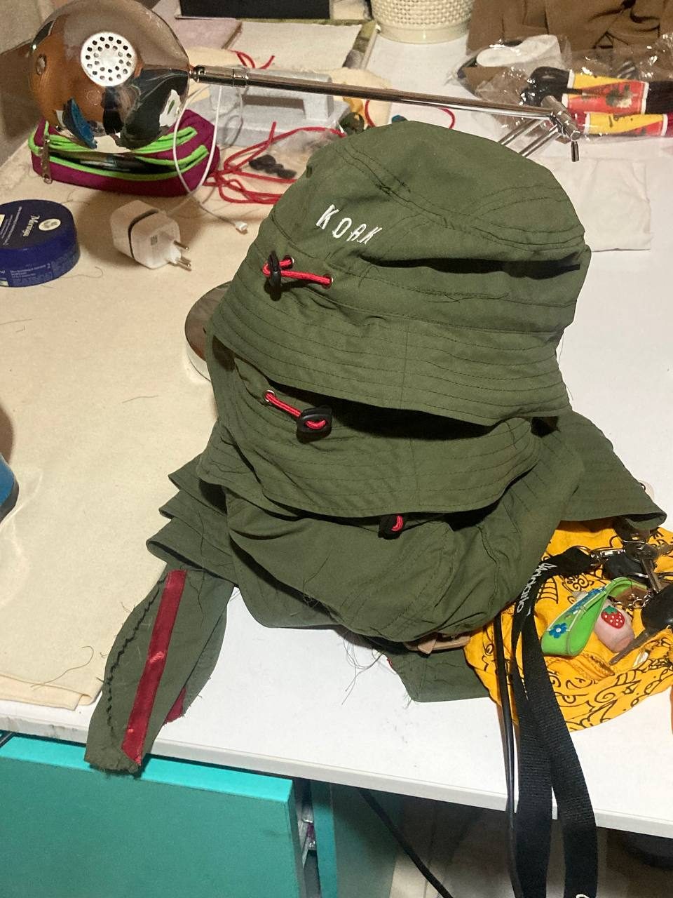 Stack of olive-green bucket hats on the sewing table