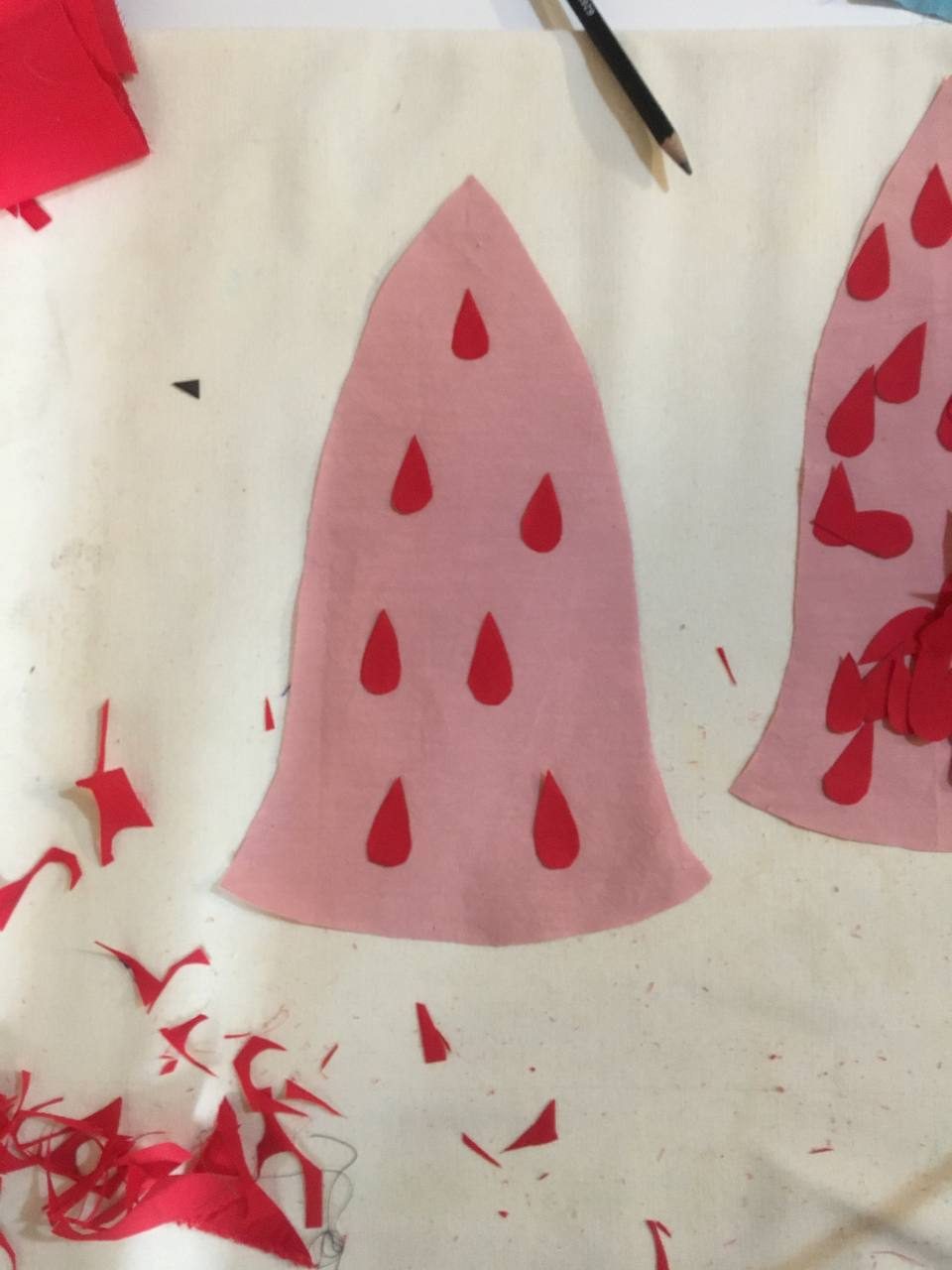 Pink strawberry applique pieces being cut on the worktable