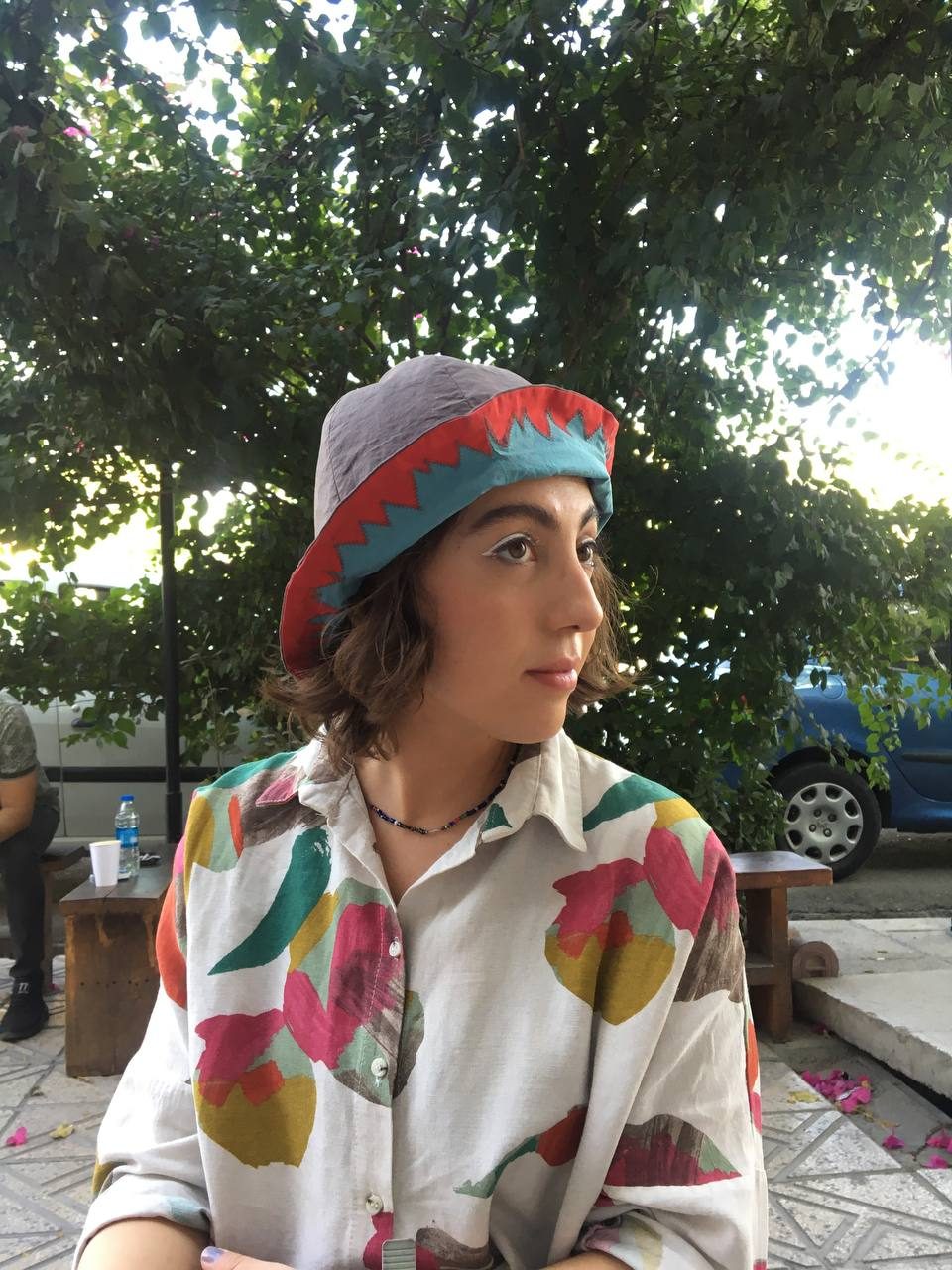Portrait of a model in a strawberry-patterned beret and colourful shirt