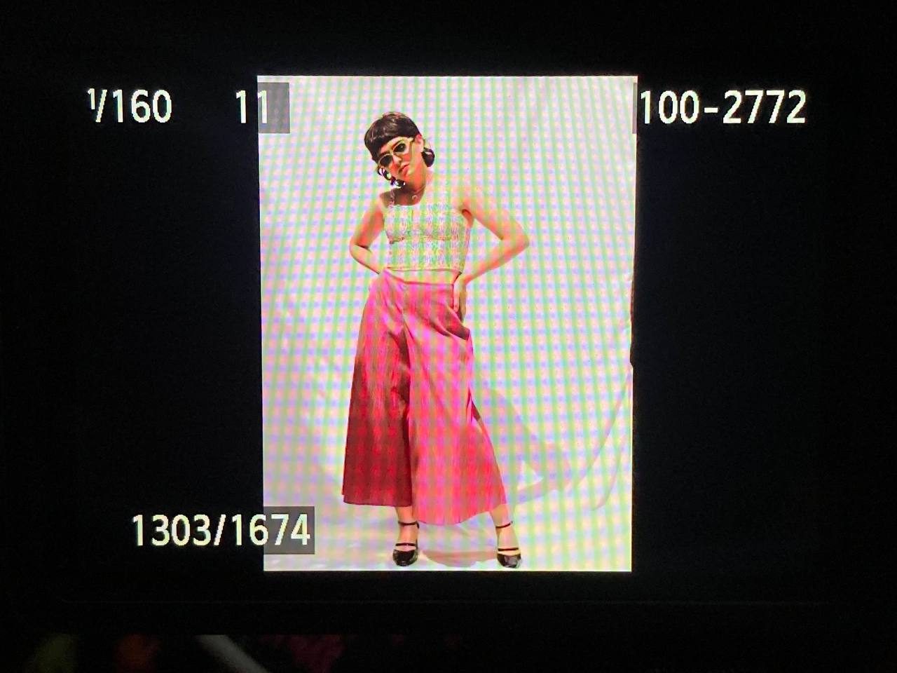 Model in a pale top and wide pink trousers