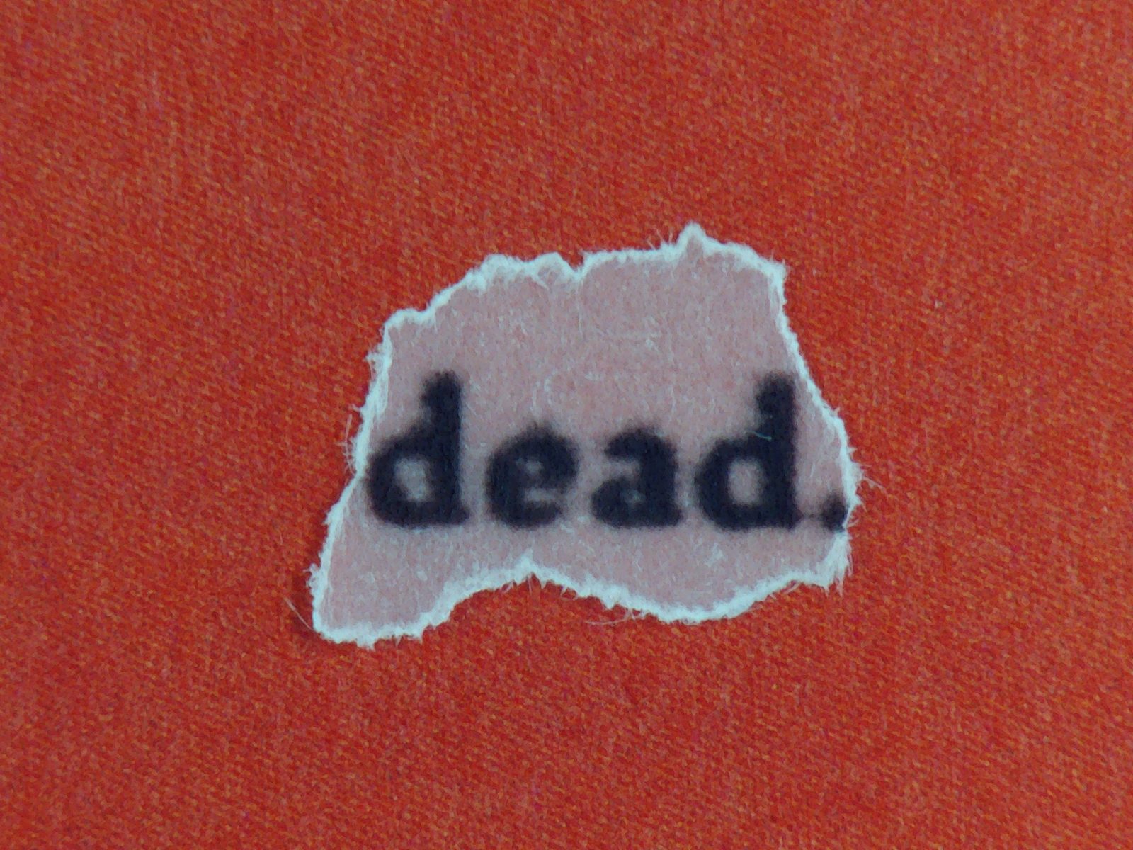 Vermilion page with a single torn fragment reading dead