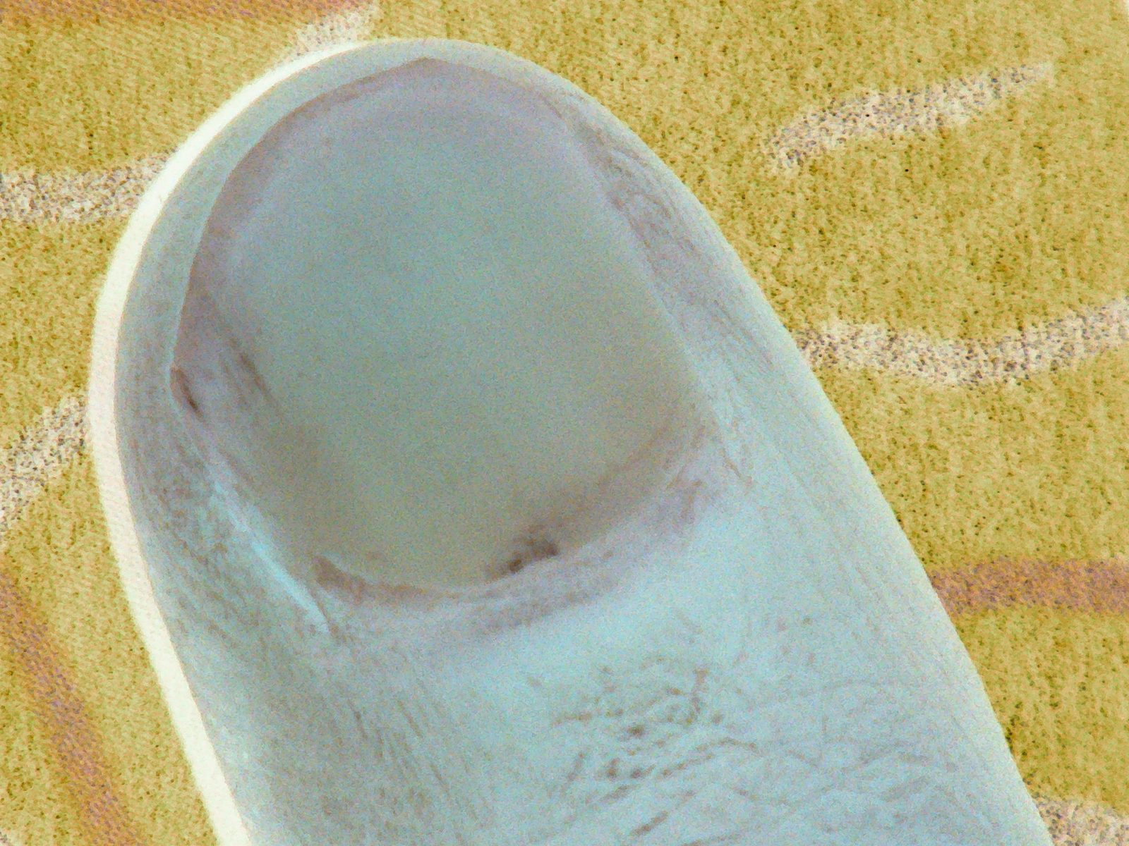 Fingertip resting on an ochre page with purple line drawings