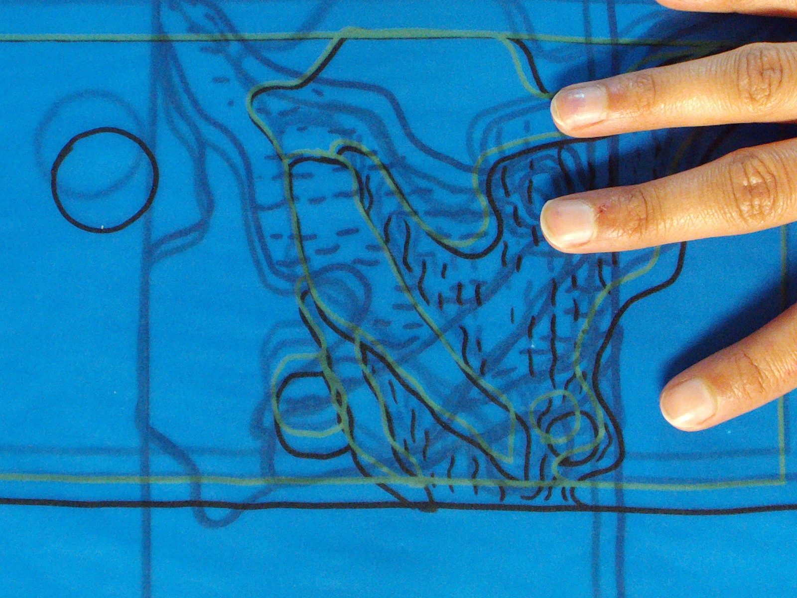 Hand resting on a cobalt blue silkscreened page