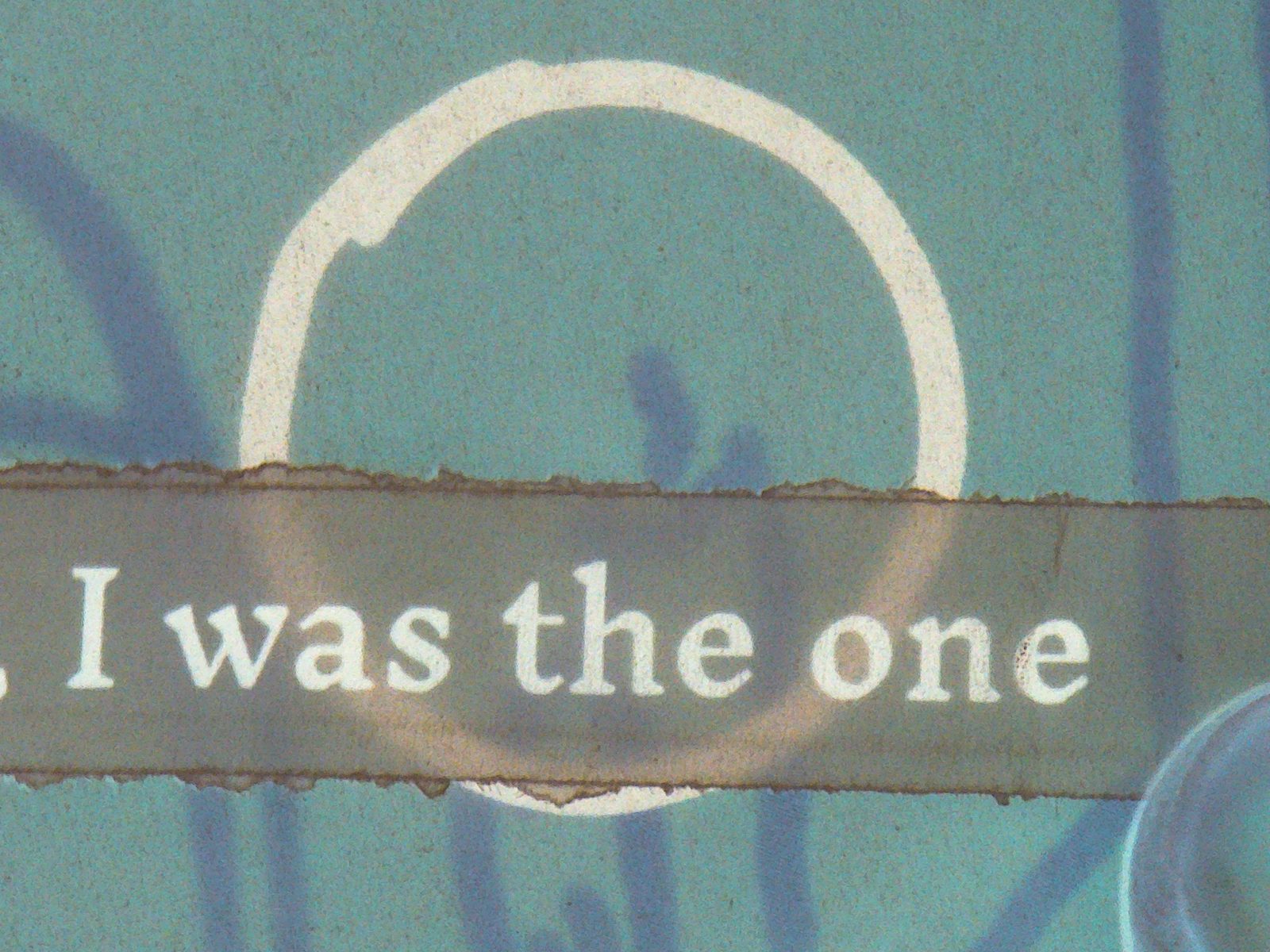 Torn text reading I was the one beside a white circle on a green page