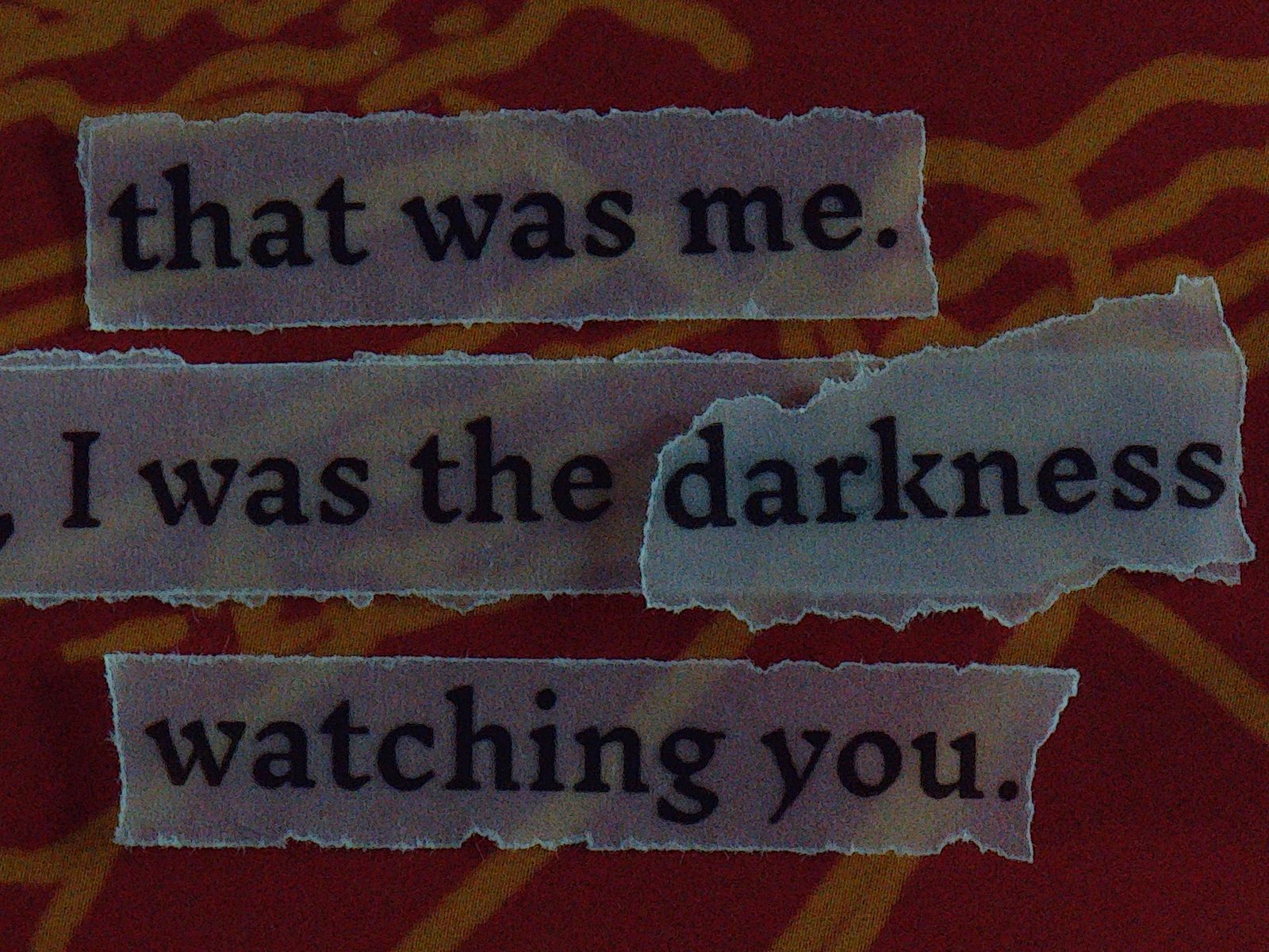 Deep red page with torn text reading I was the darkness watching you