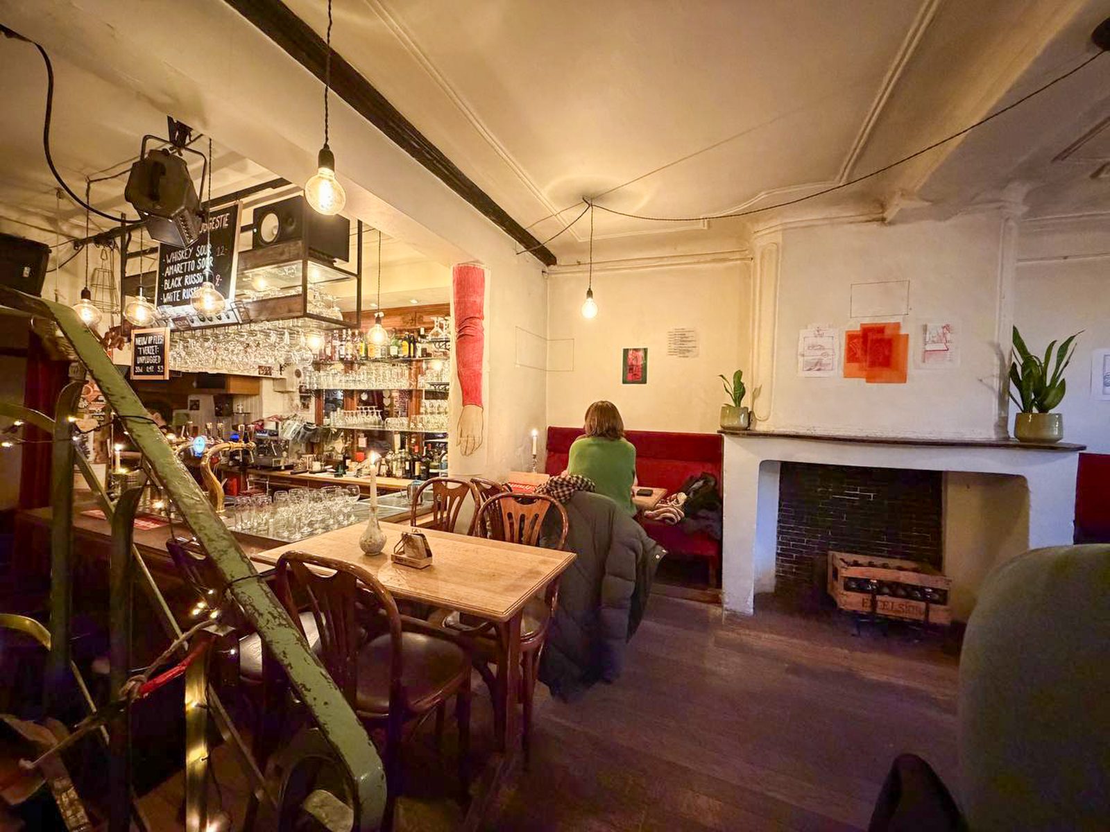 Wide view of the exhibition space with works hung above red benches
