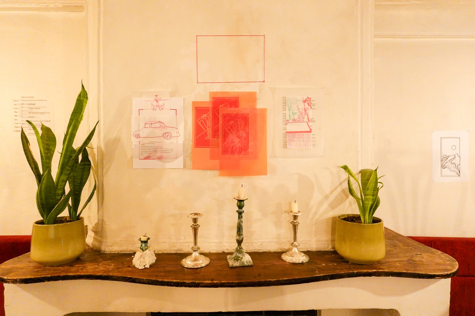 Installation view with candlesticks on a wooden table