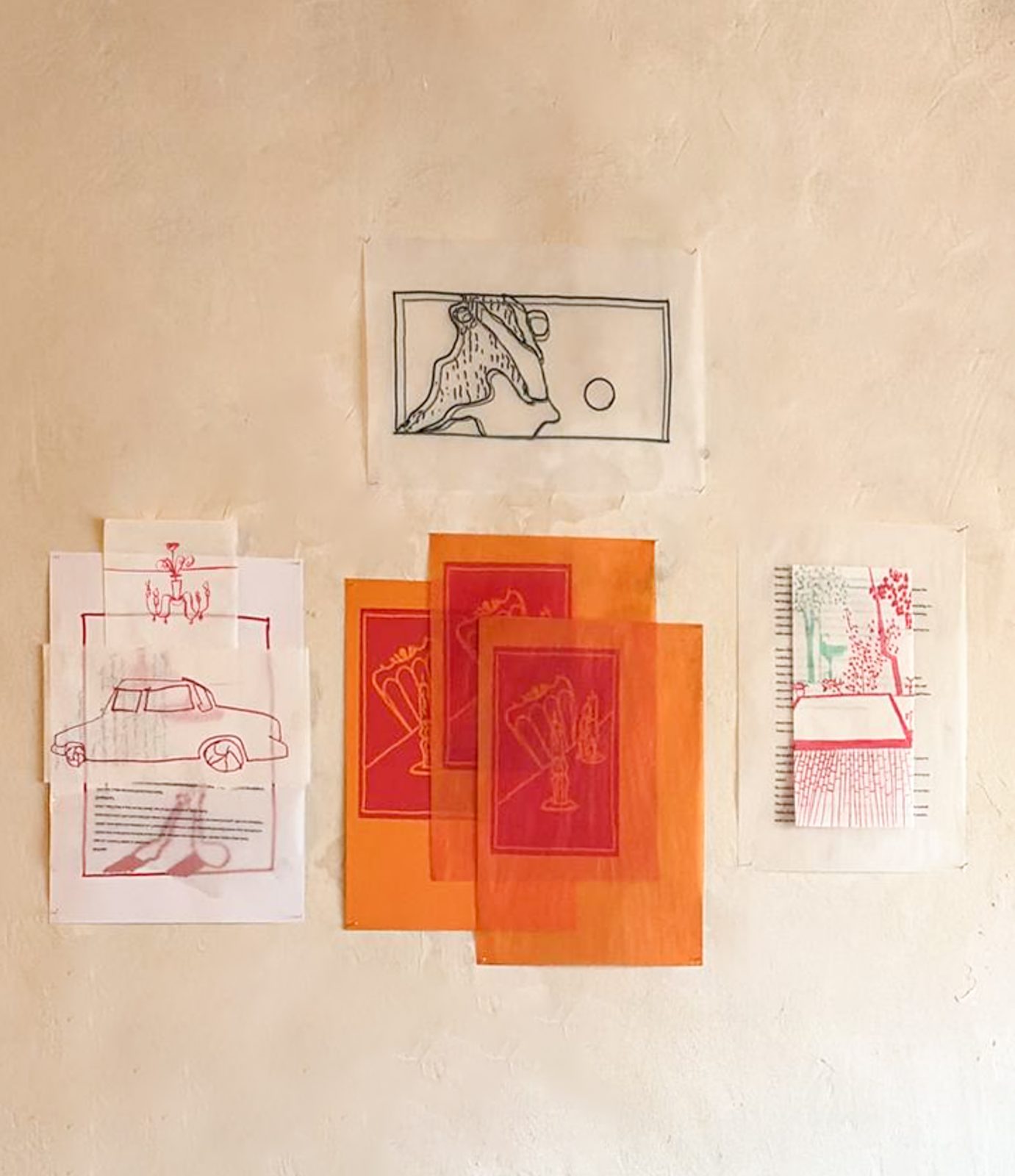 Cluster of silkscreen prints and translucent orange overlays on a white wall